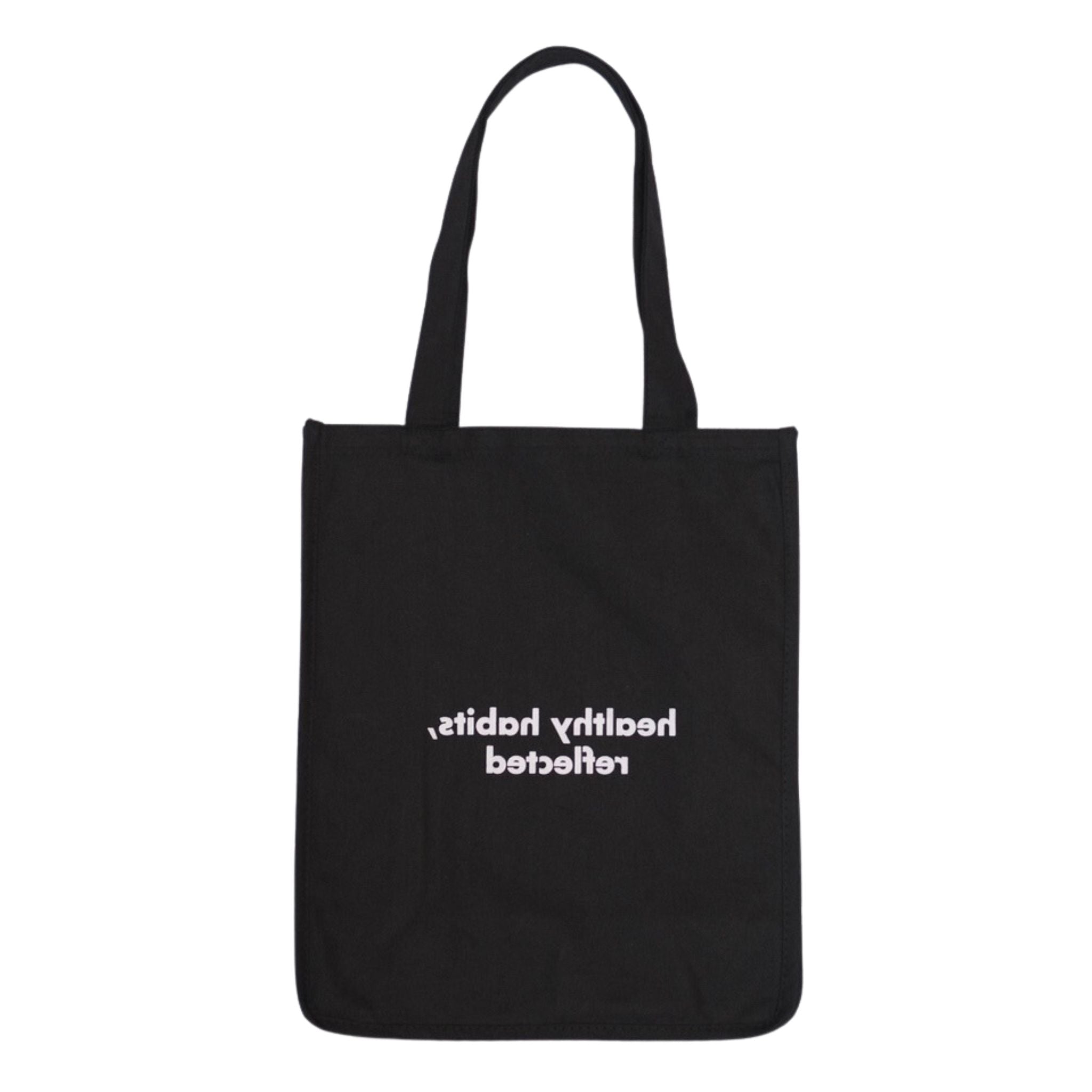 The Reflection Tote is a black bag with handles, featuring “healthy habits, reflected” in white mirrored text—perfect for mindful style.