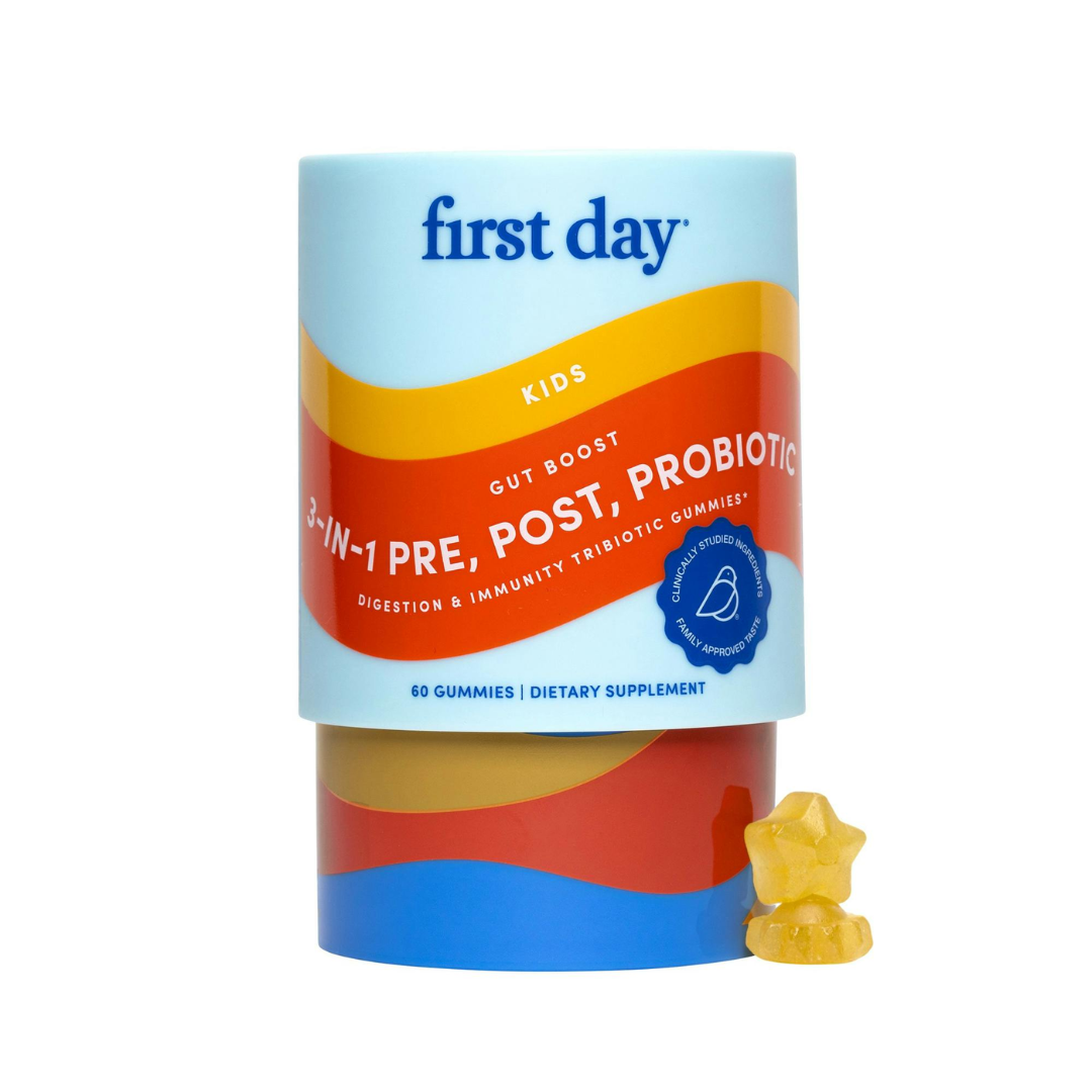 Colorful cylindrical container of 'first day' kids dietary supplement gummies on a white background