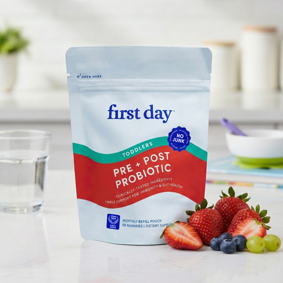 First Day pre + post probiotic package with strawberries and blueberries on a table.