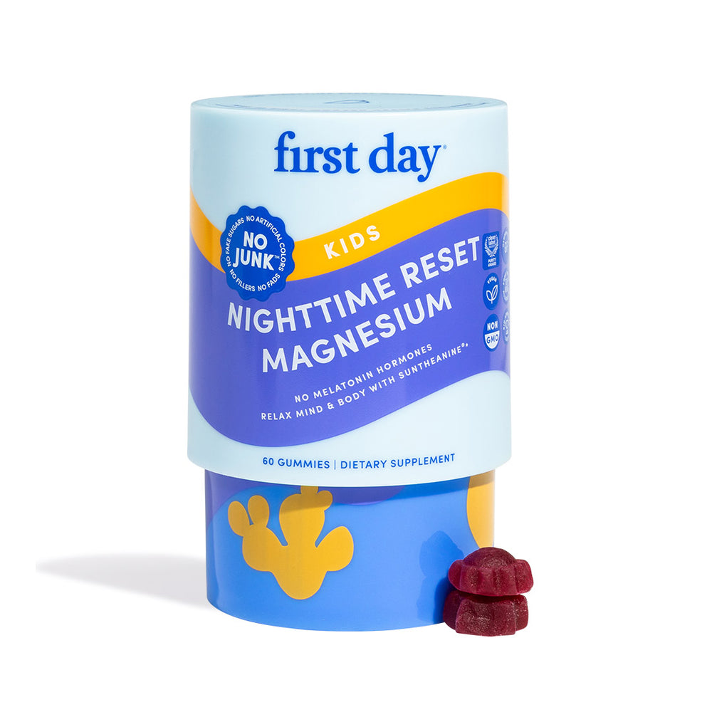 A container of First Day Life Inc. Kids’ Nighttime Reset Magnesium Add-On, labeled “No Junk,” is shown with two red gummies. The packaging is blue and purple and reads no melatonin hormones.