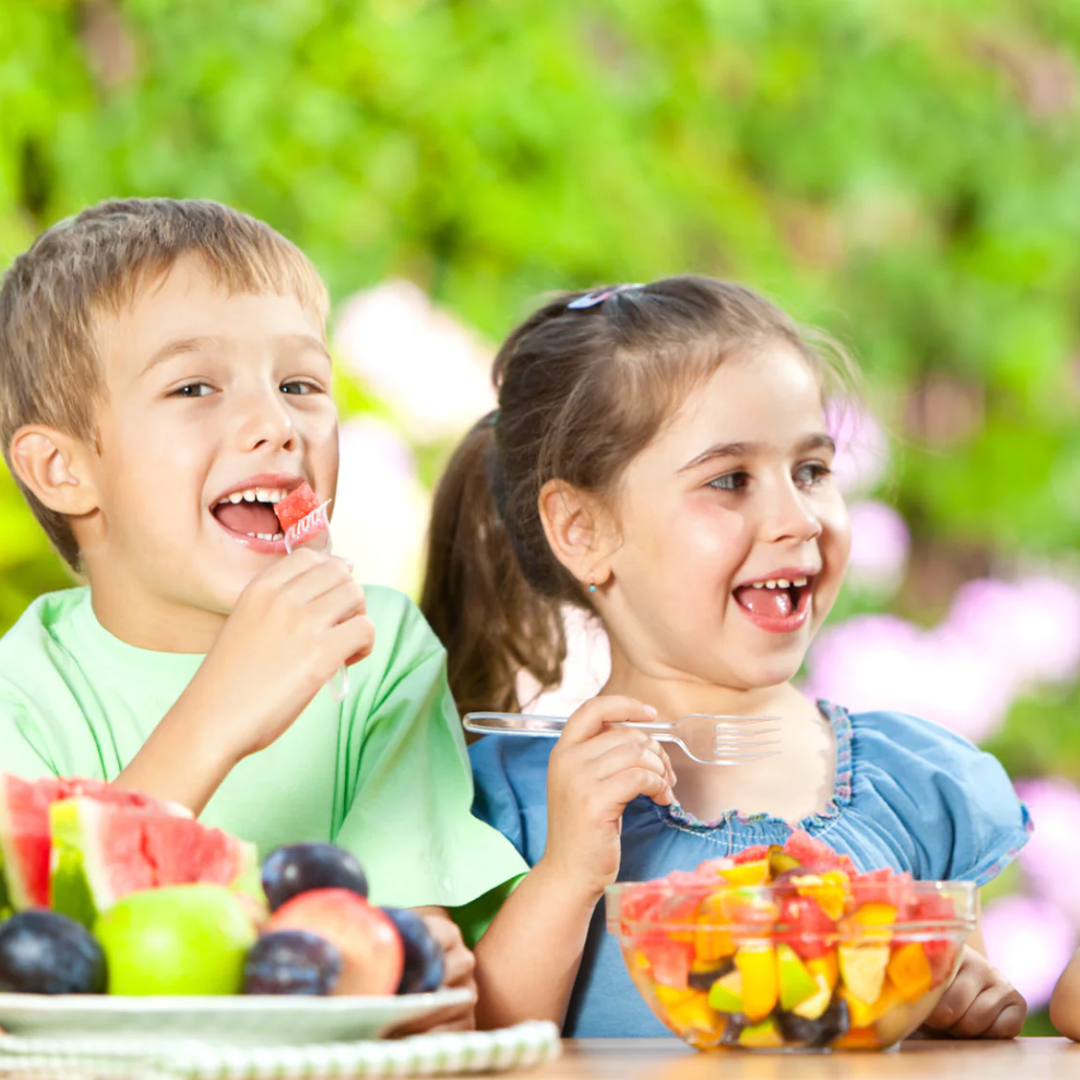Kids eating fruit salad.