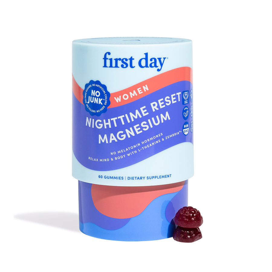 A container of Women’s Nighttime Reset Magnesium gummies for women, labeled melatonin-free and junk-free. Two dark red gummies beside it, formulated with calming ingredients to support restorative sleep.