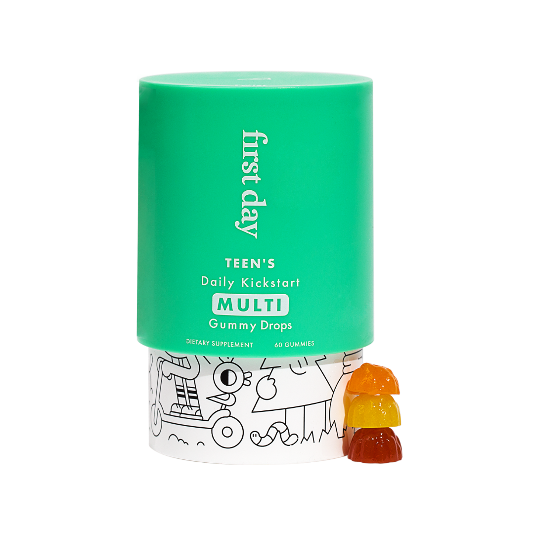 A green container labeled first day TEENS Daily Kickstart MULTI Gummy Drops stands on a white base with doodles. Next to it are four colorful gummy drops stacked in orange, red, yellow, and orange colors.