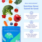 A blue tub labeled 'TODDLERS' SUPERFOOD MULTI' with floating fruit and vegetable illustrations and marketing text on a light blue background. Visible text includes 'REAL WHOLESOME Nutrition Never Tasted So Good' and product claims about bright, fruity gummies and high-quality ingredients.